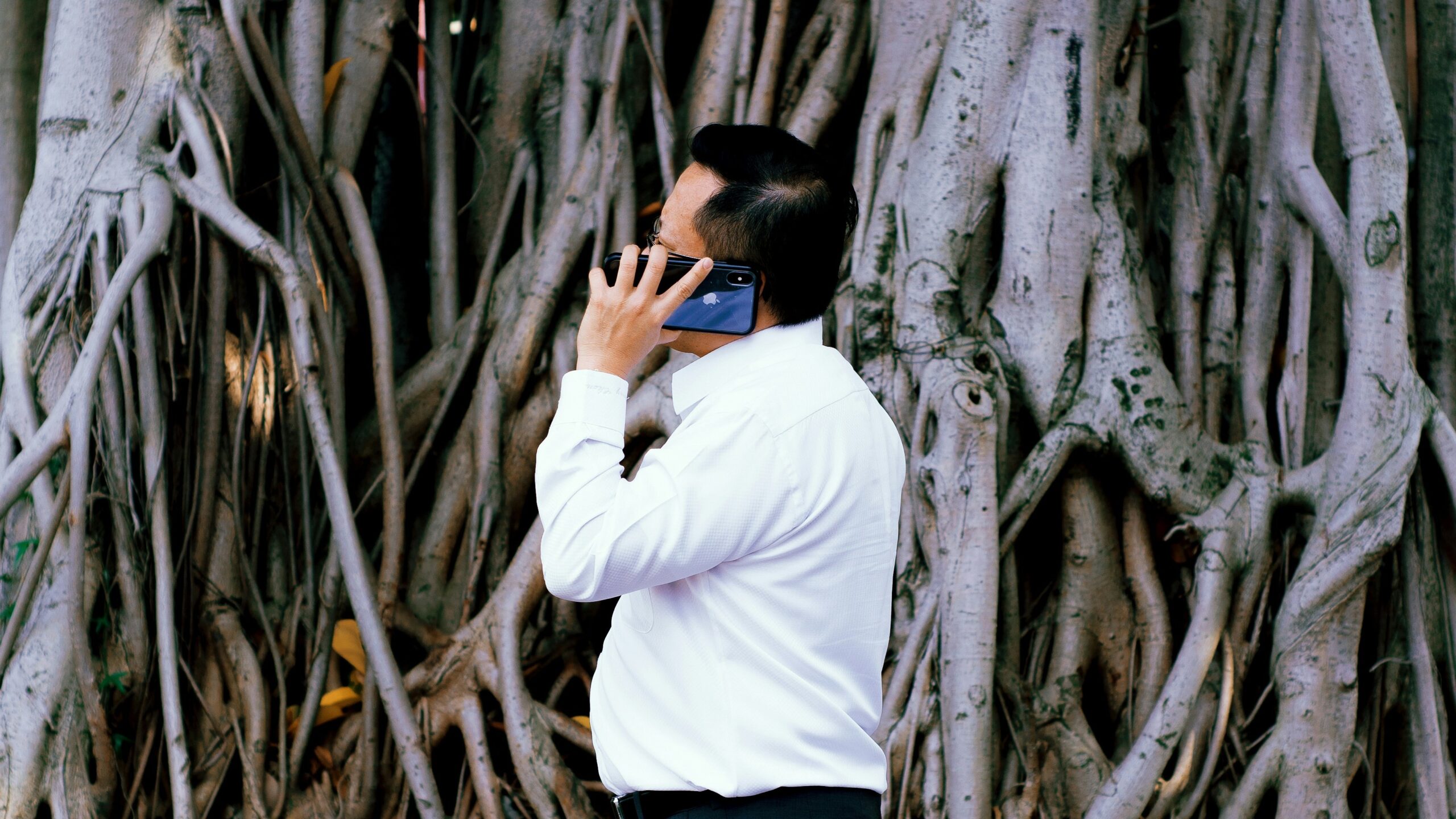 A person frantically jotting down notes while on a phone call