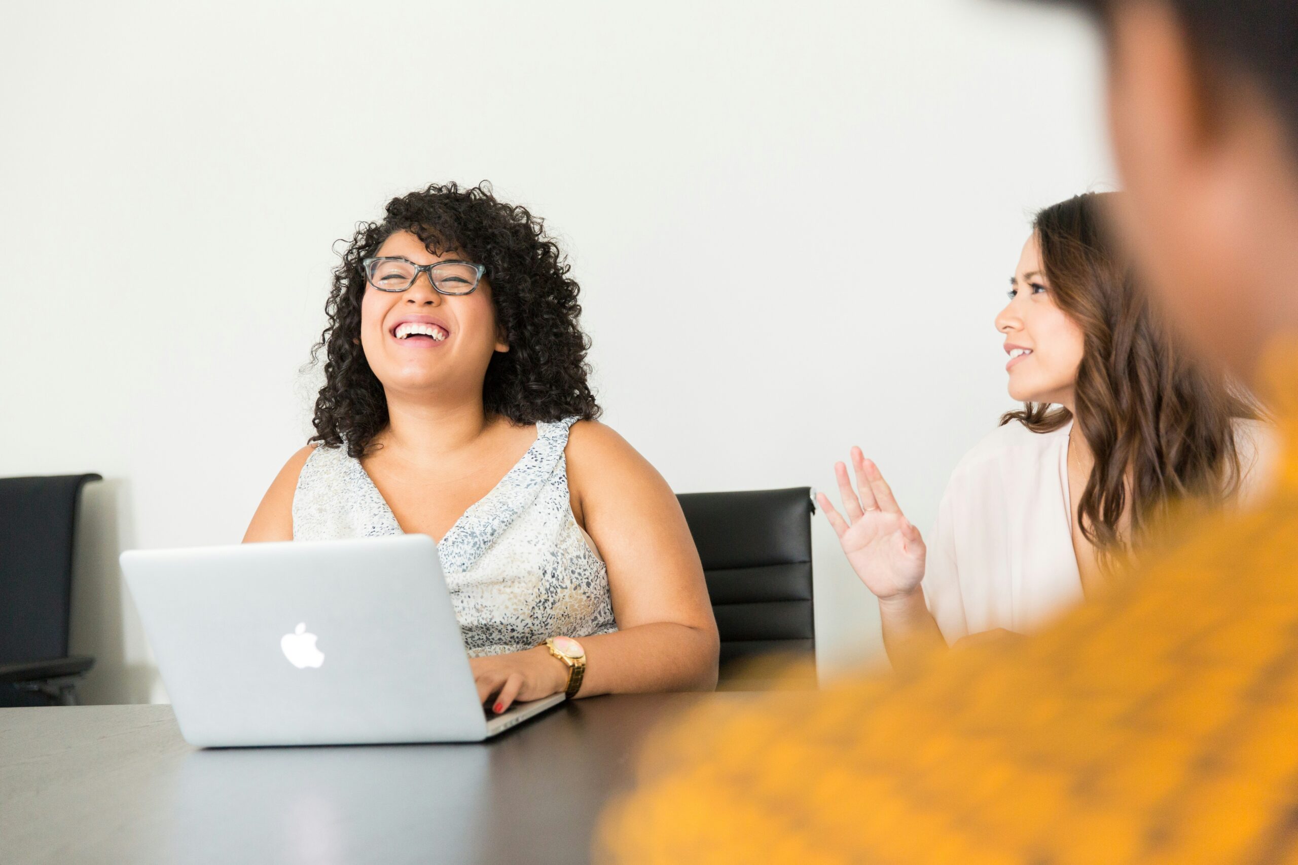Happy employees collaborating around a conference table with integrated technology